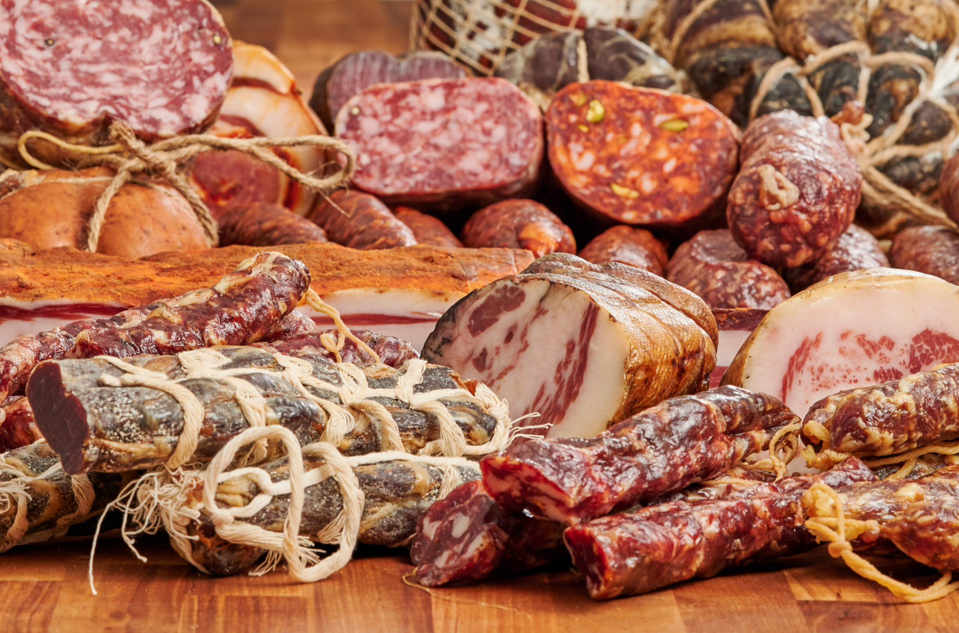Several kinds of salami spread out on a table